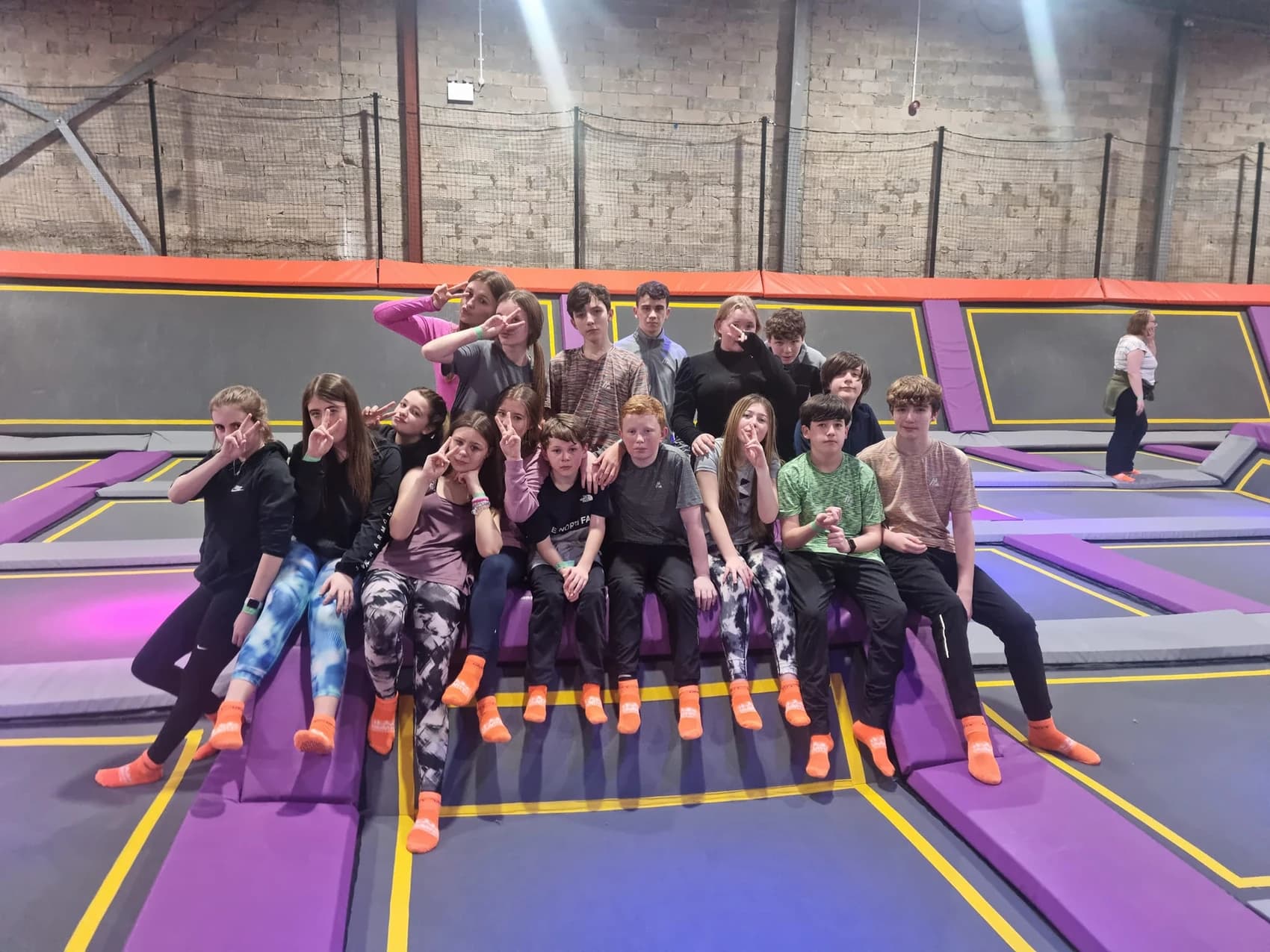 A picture of a group of teenagers posing together at an indoor inflatable park.