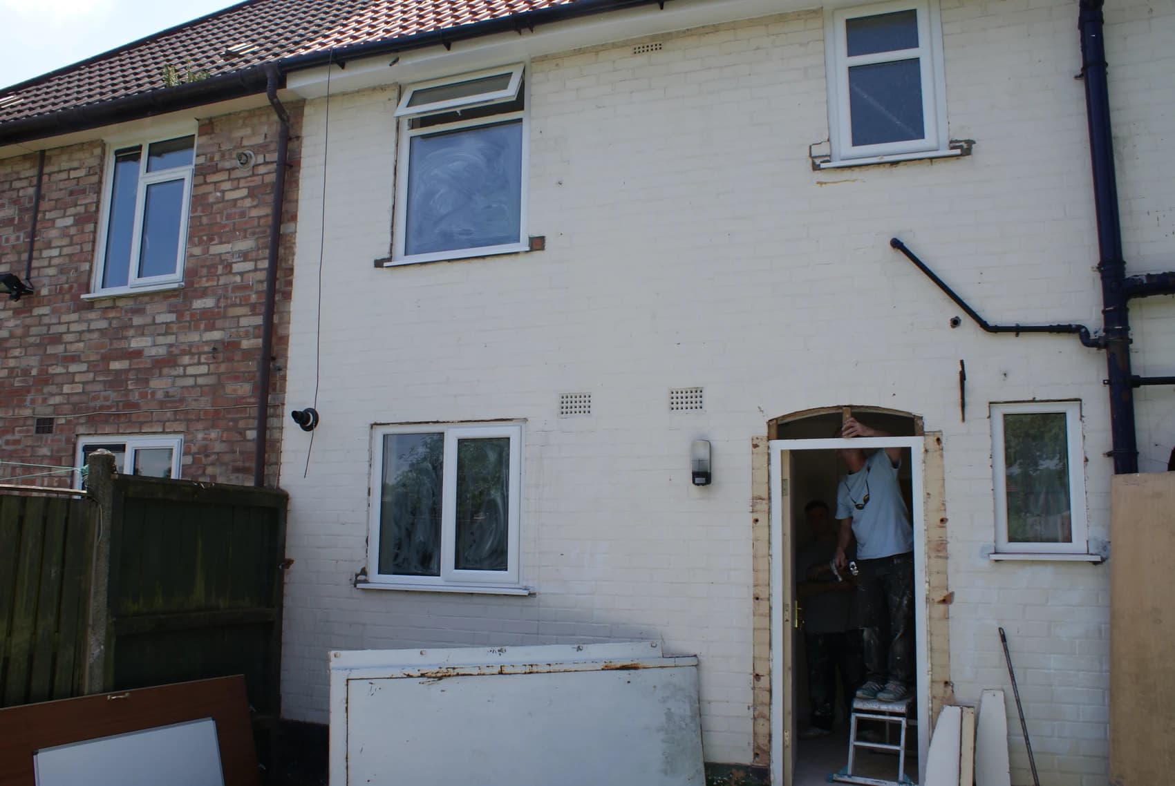 A picture of a man changing a door frame as part of a house renovation.