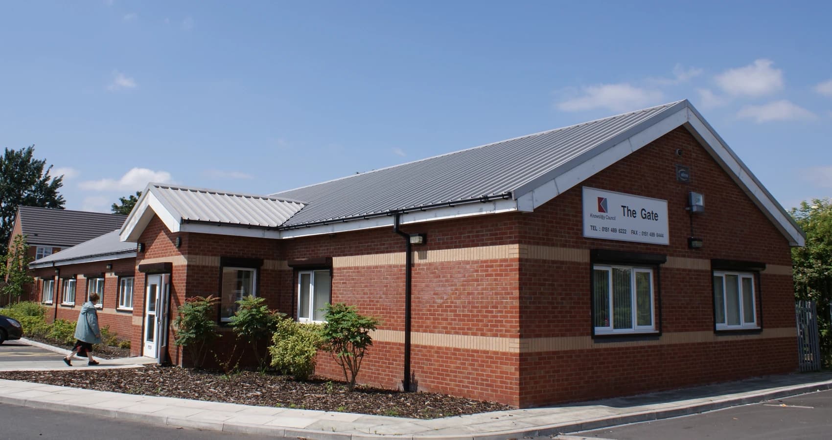 A picture of The Gate Community Centre prior to its extension, with a local community member walking in.